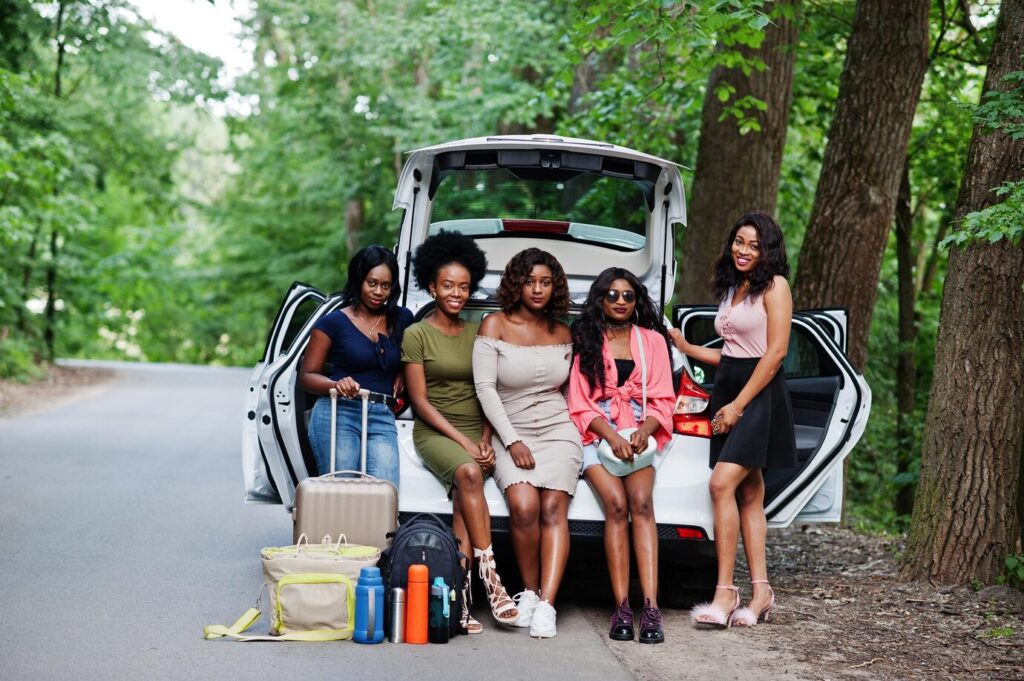 group-five-happy-african-american-traveler-girls-sitting-car-open-trunk_627829-13439